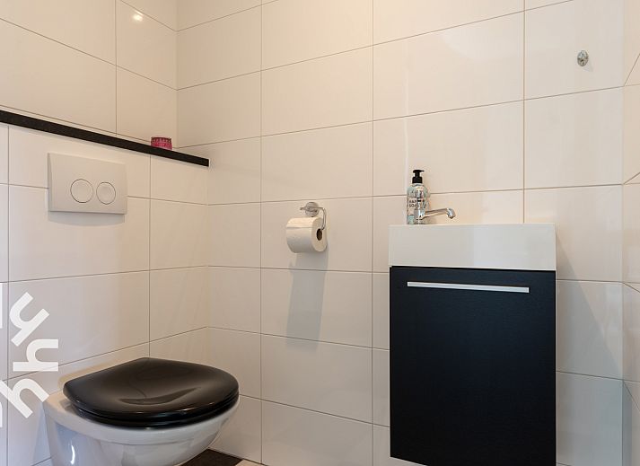 Inkomhal van vakantiehuis OV404 in Den Ham, Twente met moderne trap en deur naar de tuin.