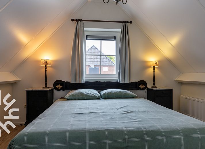 Inkomhal van vakantiehuis OV404 in Den Ham, Twente met moderne trap en deur naar de tuin.