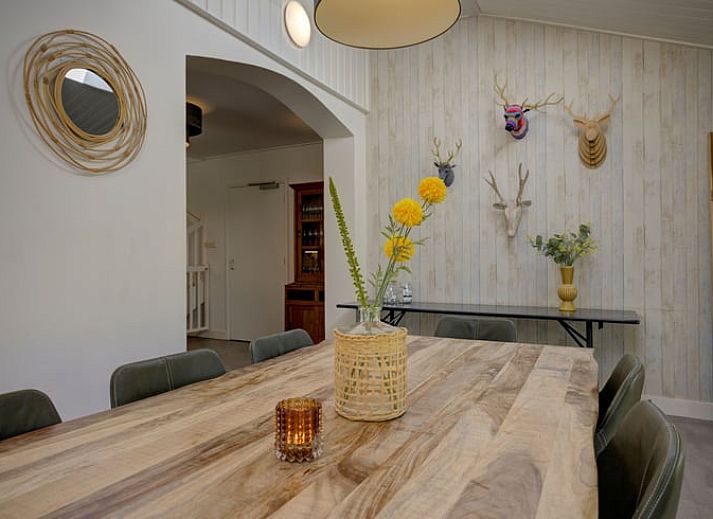 Gemuetliches Wohnzimmer im Ferienhaus in de Lutte, Twente, mit buntem Sofa, Holzofen und grossem Esstisch fuer einen komfortablen Aufenthalt.