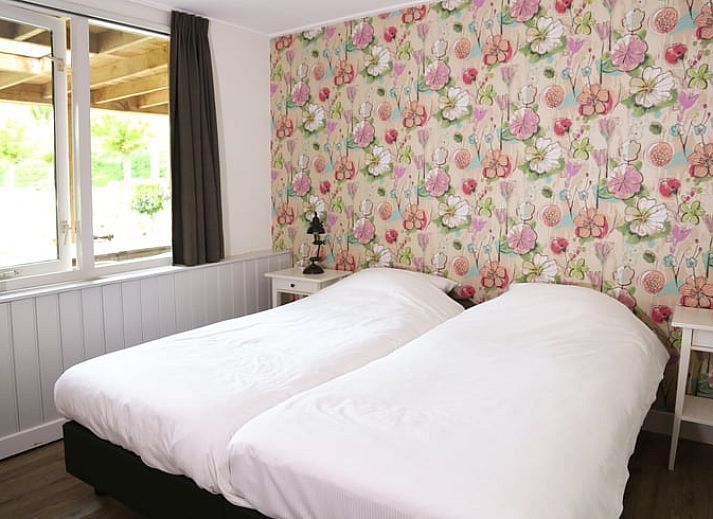 Gemuetliches Wohnzimmer im Ferienhaus in de Lutte, Twente, mit buntem Sofa, Holzofen und grossem Esstisch fuer einen komfortablen Aufenthalt.