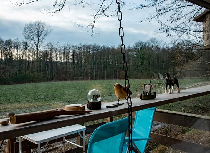 Veranda des Ferienhauses in De Lutte in Twente mit Blick auf gruene Felder und eine rustikale Blase in Overijssel.