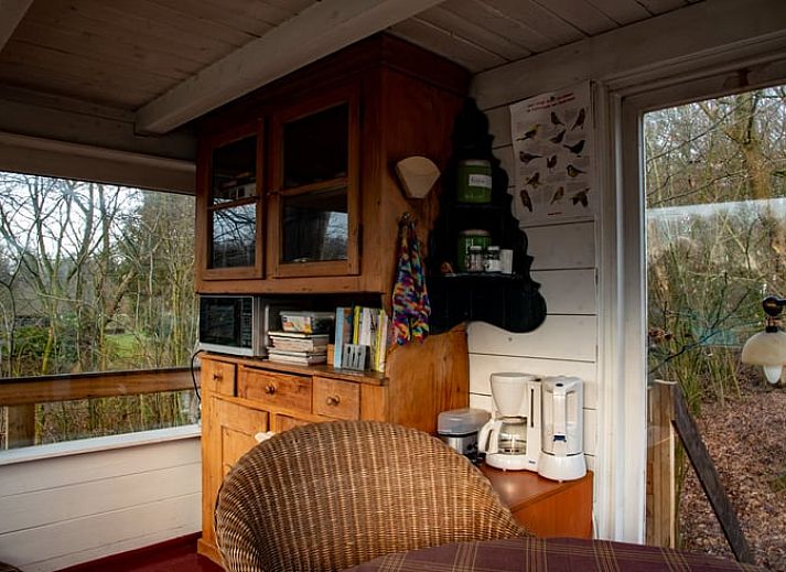 Veranda des Ferienhauses in De Lutte in Twente mit Blick auf gruene Felder und eine rustikale Blase in Overijssel.