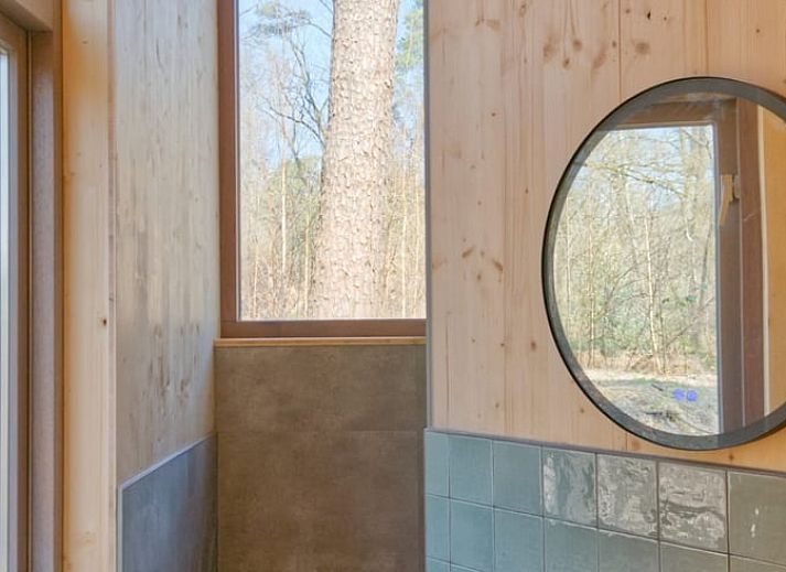 Gezellige zithoek in Vakantiehuisje in de Lutte, Twente, met uitzicht op de natuur.