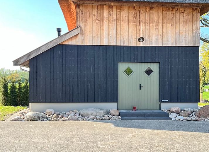 Aussenansicht des Ferienhauses in de Lutte in Twente, Overijssel, umgeben von Blumen und Natur.