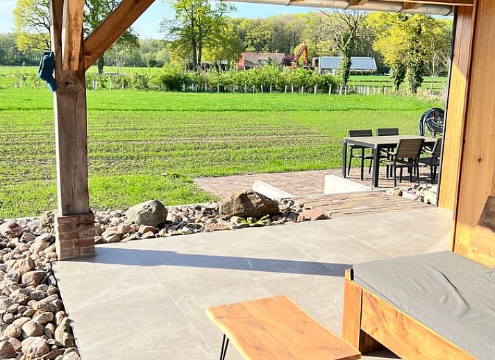 Aussenansicht des Ferienhauses in de Lutte in Twente, Overijssel, umgeben von Blumen und Natur.