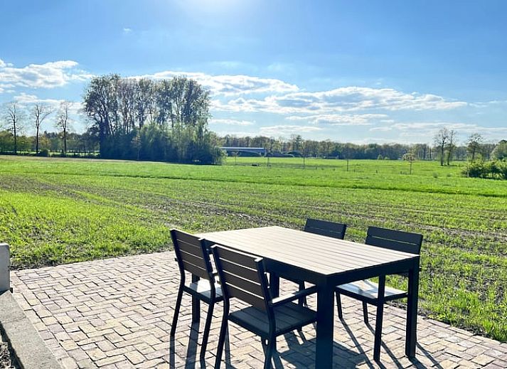 Aussenansicht des Ferienhauses in de Lutte in Twente, Overijssel, umgeben von Blumen und Natur.