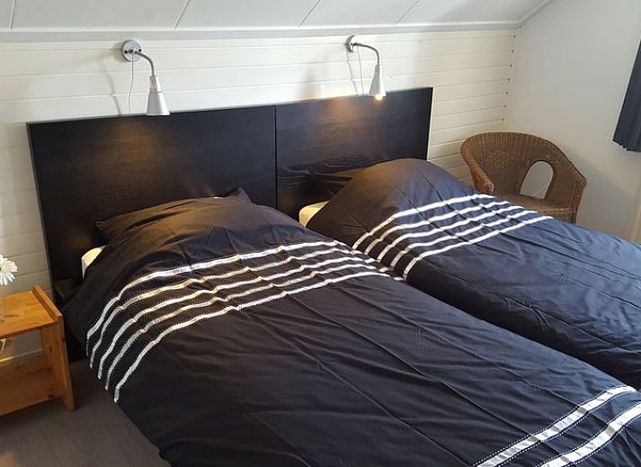 Cozy living room in vacation home Hezingen, Twente, with modern furnishings and wood stove.