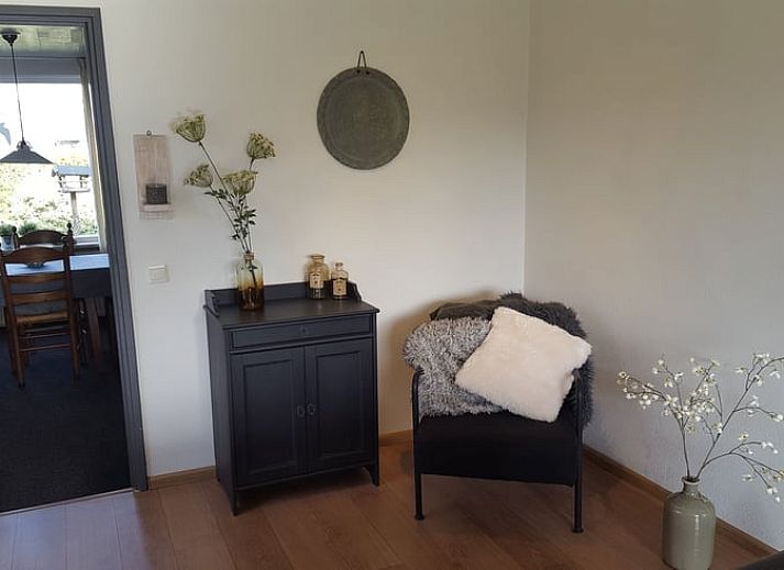Cozy living room in vacation home Hezingen, Twente, with modern furnishings and wood stove.