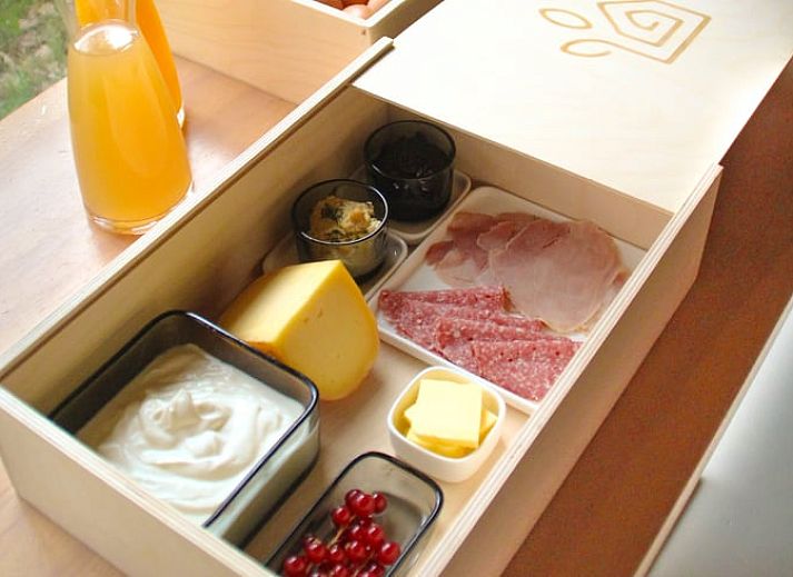 Cozy living room in Cottage in Beuningen, Twente with colorful cushions and wooden furniture.
