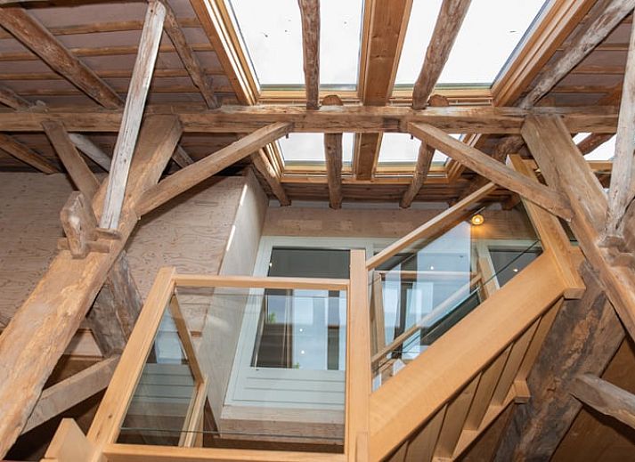Cozy living room in Cottage in Beuningen, Twente with colorful cushions and wooden furniture.
