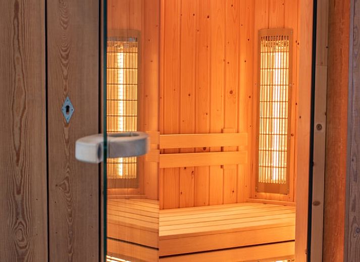 Cozy living room in Cottage in Beuningen, Twente with colorful cushions and wooden furniture.