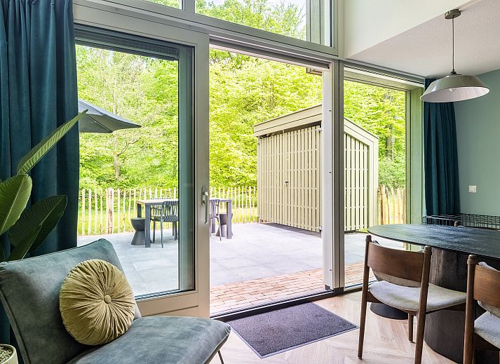 Stijlvolle woonkamer in 4-6-persoons hondenwoning Beuningen, Twente met uitzicht op terras en natuur.