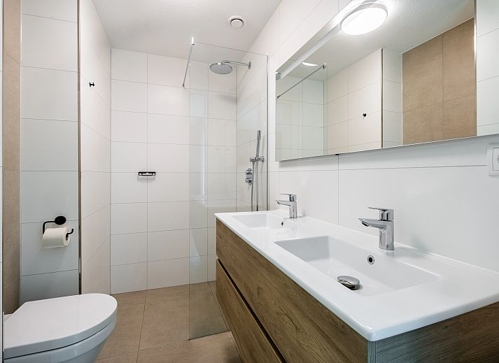 Gezellige zithoek met kunst aan de muur in 4-6-persoons hondenwoning in Beuningen, Twente, Overijssel.