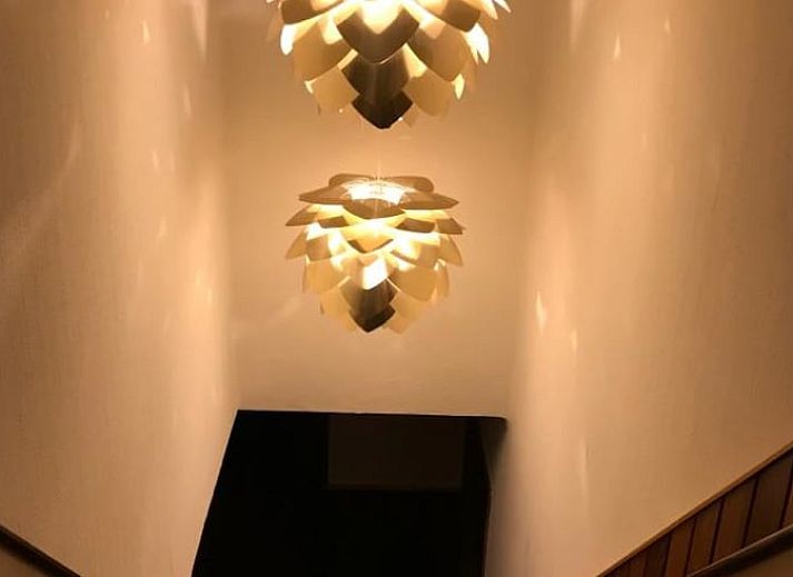 Esszimmer und Wohnzimmer in Cottage in Weerselo, Ferienhaus in Twente, Overijssel mit stimmungsvoller Beleuchtung.