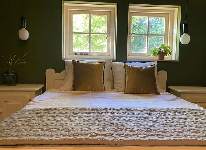 Cozy kitchen of Huisje in Reutum, vacation home in Twente, Overijssel, with wooden table and atmospheric hanging lamps.