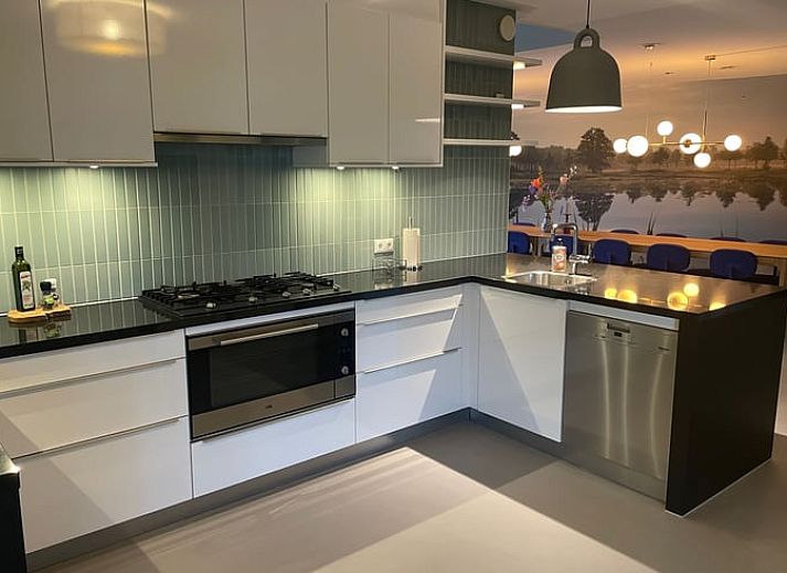 Ferienhaus in Rijssen mit gruenem Dach und bunten Blumen in Twente, Overijssel.