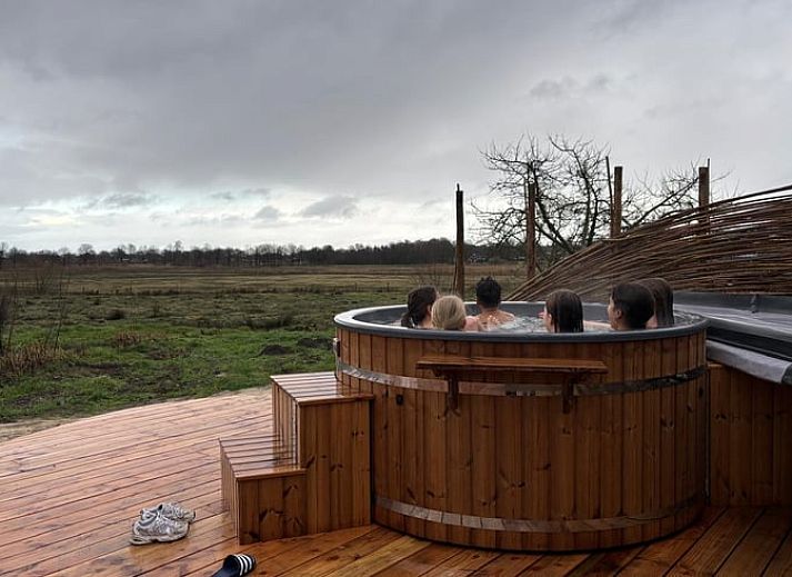 Gezellige woonkamer in Huisje in Rijssen, vakantiehuis in Twente, Overijssel met kleurrijke inrichting en uitzicht op de groene natuur.