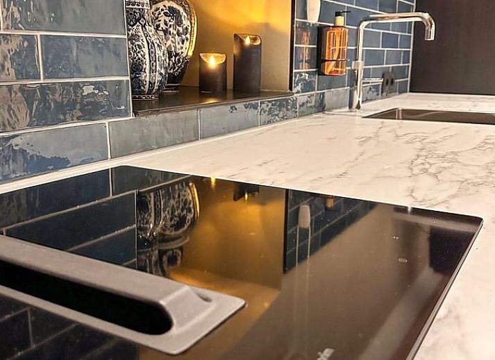 Cozy living room of Huisje in Rossum, vacation home in Twente, Overijssel, with fireplace and comfortable seating.