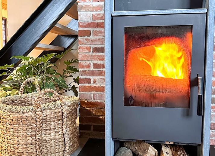 Cozy living room of Huisje in Rossum, vacation home in Twente, Overijssel, with fireplace and comfortable seating.