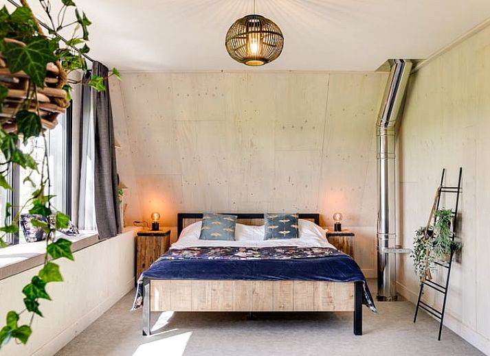 Stylish bathroom of Huisje in Rossum, vacation home in Twente, Overijssel, with wooden details and plants.