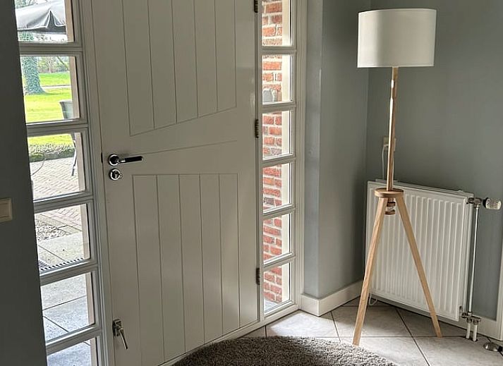 Gemuetliches Schlafzimmer in Cottage in Rossum, Ferienhaus in Twente, Overijssel, mit Blick auf die gruene Natur durch ein grosses Fenster.