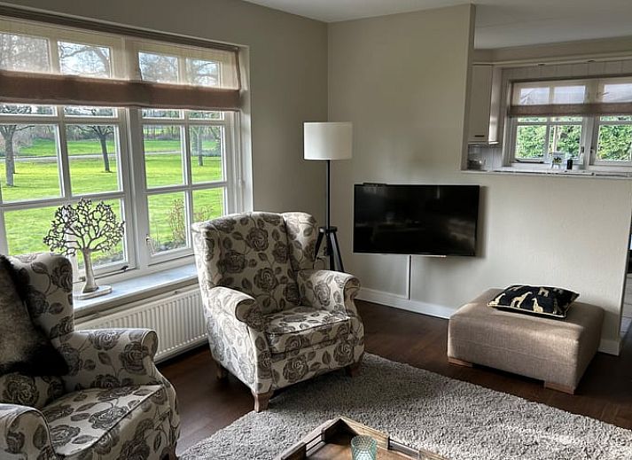 Gemuetliches Schlafzimmer in Cottage in Rossum, Ferienhaus in Twente, Overijssel, mit Blick auf die gruene Natur durch ein grosses Fenster.