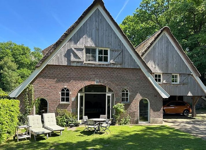 Comfortable sitting area in cottage Hengelo, Twente, with fireplace and wooden beams in Overijssel.