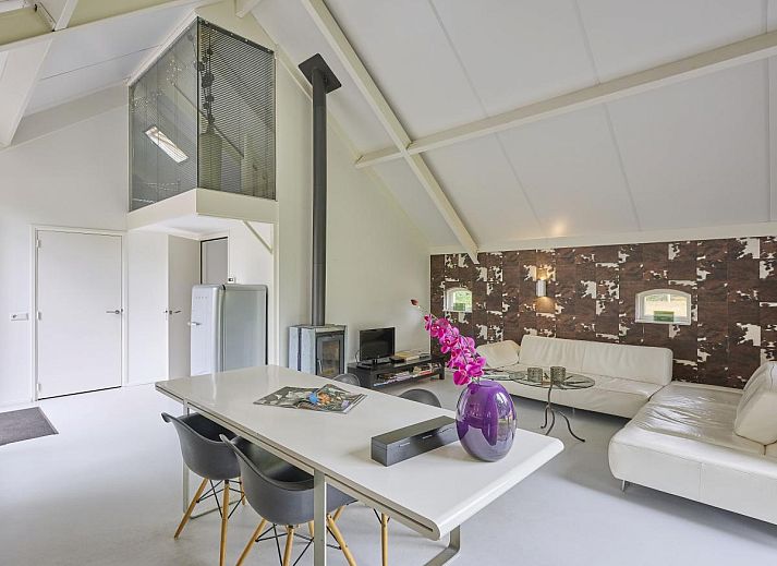 Design Lodge Twente Ferienhaus mit Terrasse und Liegestuehlen in Haaksbergen, Overijssel, umgeben von gruener Natur.