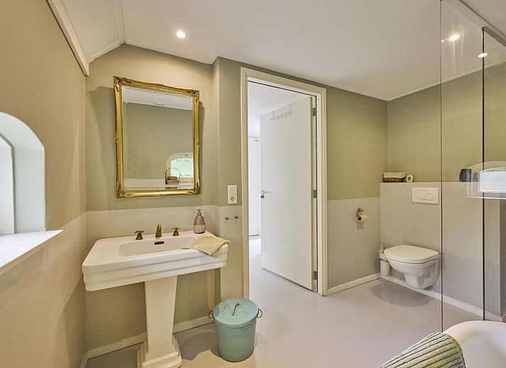 Design Lodge Twente Ferienhaus mit Terrasse und Liegestuehlen in Haaksbergen, Overijssel, umgeben von gruener Natur.