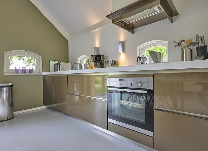 Charmantes Aeusseres der Design Lodge Twente in Haaksbergen, Overijssel, mit Backsteinfassade und ueppigem Garten.