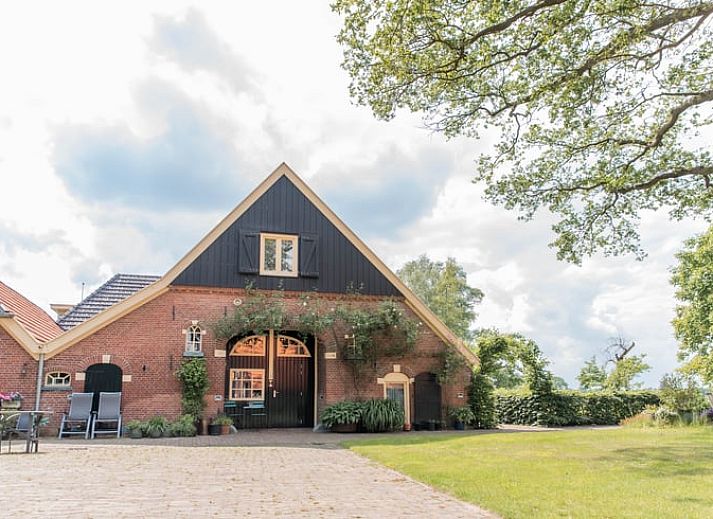 Charmant vakantiehuisje in Diepenheim, Twente met groene omgeving en traditionele architectuur.