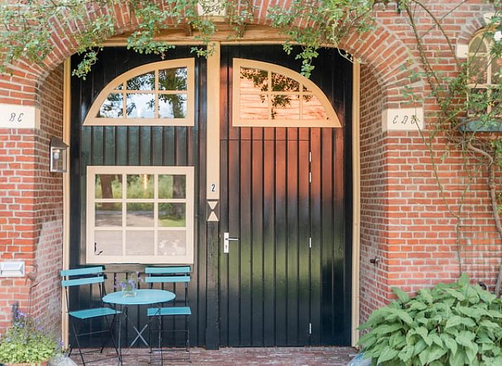 Charmant vakantiehuisje in Diepenheim, Twente met groene omgeving en traditionele architectuur.