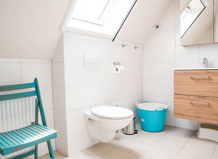 Buitenruimte van vakantiehuisje in Diepenheim met rustieke tafel en bloemen.