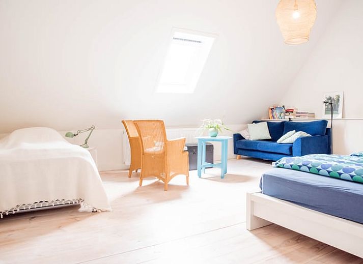 Buitenruimte van vakantiehuisje in Diepenheim met rustieke tafel en bloemen.