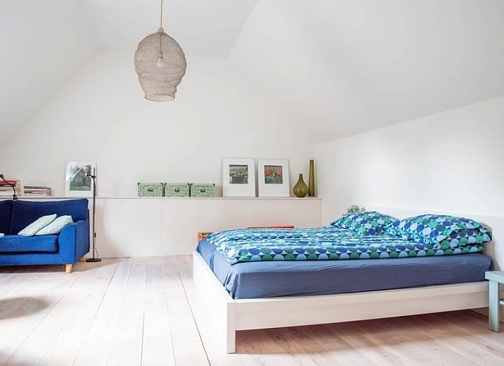 Buitenruimte van vakantiehuisje in Diepenheim met rustieke tafel en bloemen.