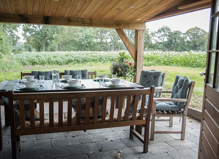 Gezellige veranda van Huisje in Diepenheim, vakantiehuis in Twente, Overijssel, omgeven door natuur met comfortabele zitgelegenheid.