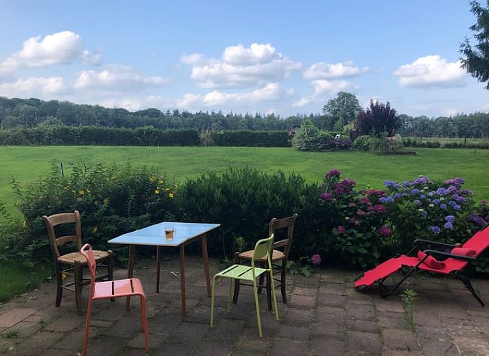 Uitzicht vanuit Huisje in Diepenheim, Twente op kleurrijke herfsttuin met laptop op vensterbank.