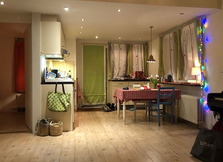 Terras van Huisje in Diepenheim, vakantieaccommodatie in Twente met groen uitzicht en spelende hond.