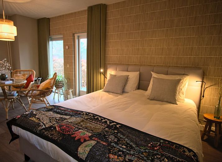 Zonnige gevel van Vakantiehuis in Oldenzaal, Twente, met zonnepanelen en groene heg voor duurzame charme.