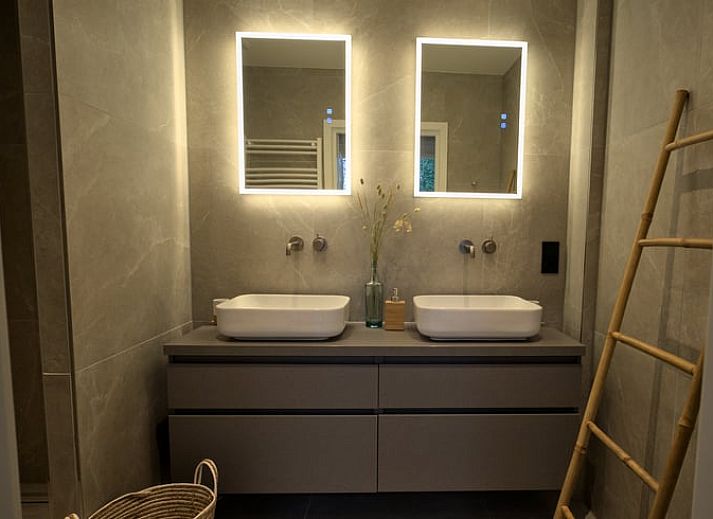 Zonnige gevel van Vakantiehuis in Oldenzaal, Twente, met zonnepanelen en groene heg voor duurzame charme.