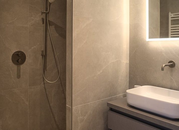 Hangende bloemenmanden en kleurrijke bloemen bij Vakantiehuis in Oldenzaal, een rustiek verblijf in Twente.