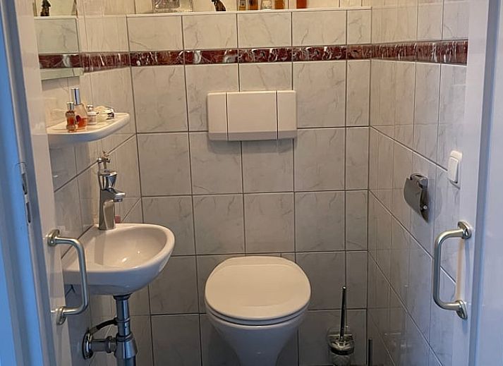 Cozy living room in Cottage in Oldenzaal vacation home in Twente, Overijssel with comfortable chairs.