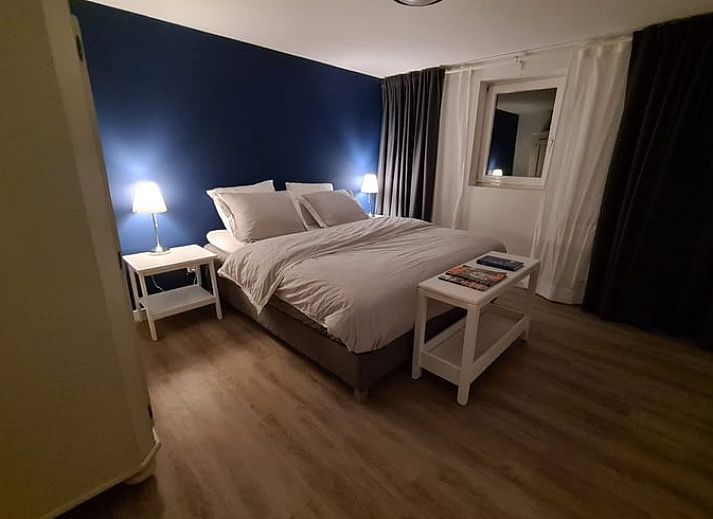 Ontspan in de tuin van Vakantiehuisje in Markelo, gelegen in het groene Twente, Overijssel, met kleurrijke bloemen en ligstoelen.