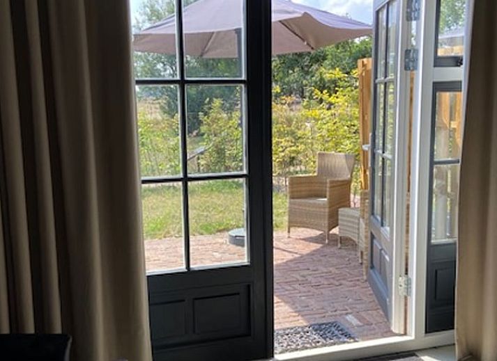 Zonnig terras bij Vakantiehuisje in Markelo, omringd door groen in Twente, Overijssel.