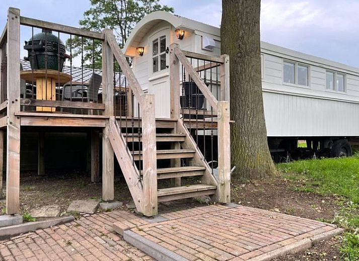 Verhoogd terras bij Vakantiehuisje in Markelo, Twente, Overijssel met houten trap en uitzicht op groene natuur.