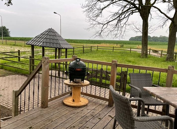 Verhoogd terras bij Vakantiehuisje in Markelo, Twente, Overijssel met houten trap en uitzicht op groene natuur.