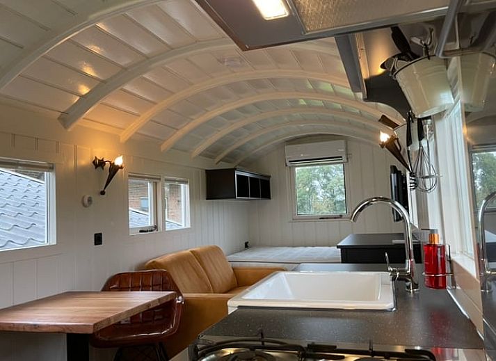 Verhoogd terras bij Vakantiehuisje in Markelo, Twente, Overijssel met houten trap en uitzicht op groene natuur.