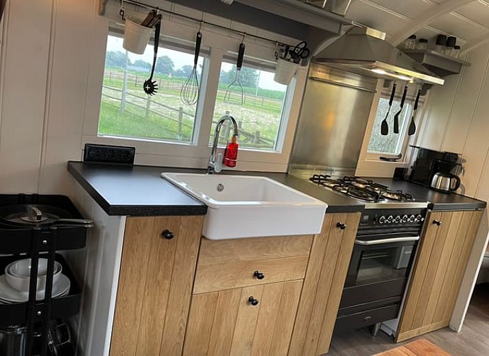 Verhoogd terras bij Vakantiehuisje in Markelo, Twente, Overijssel met houten trap en uitzicht op groene natuur.