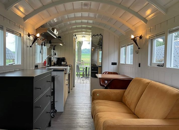 Zicht op de groene omgeving vanaf het terras van Vakantiehuisje in Markelo, Twente, Overijssel met comfortabele zitplaatsen.