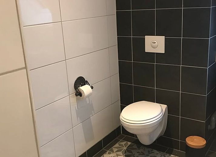 Trap in Vakantiehuisje in Markelo, een charmante vakantiewoning in Twente, Overijssel, met authentieke details en warme kleuren.